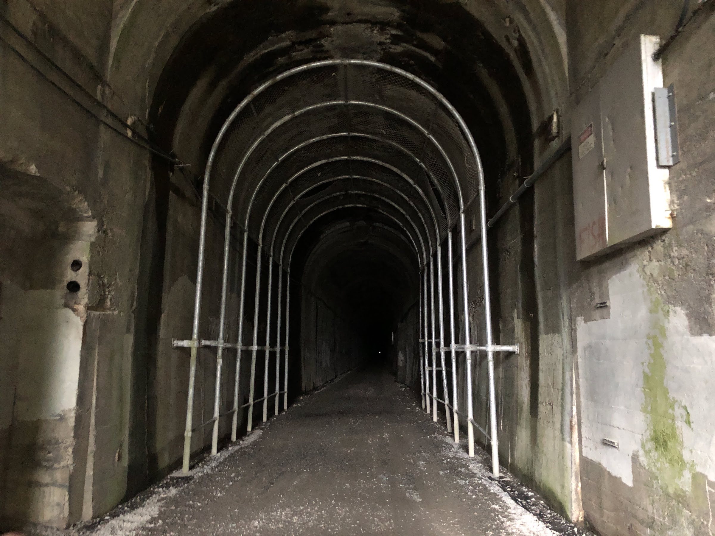 an old train tunnel with a tiny speck of light from the other end