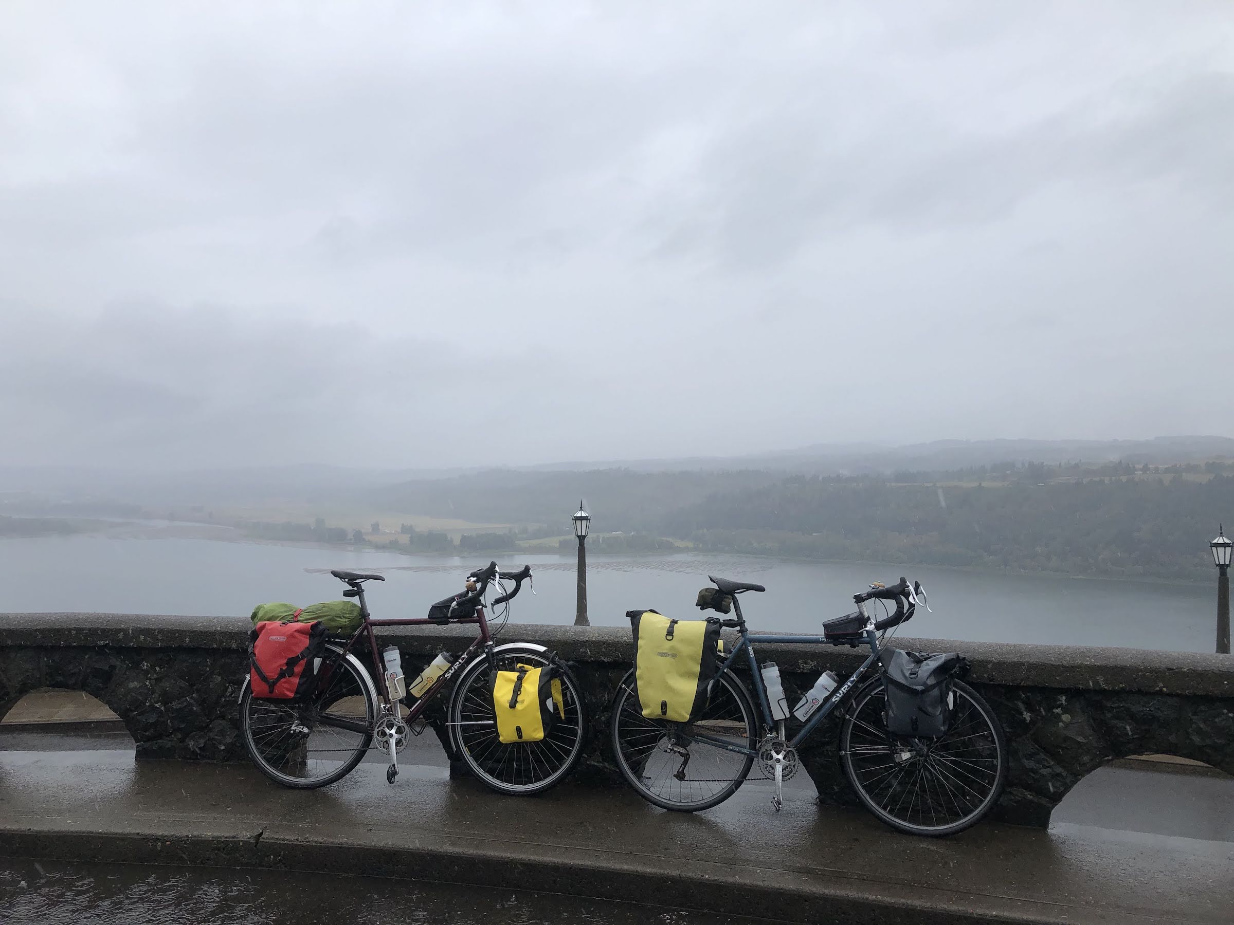two touring bikes with panniers leaning against a railing