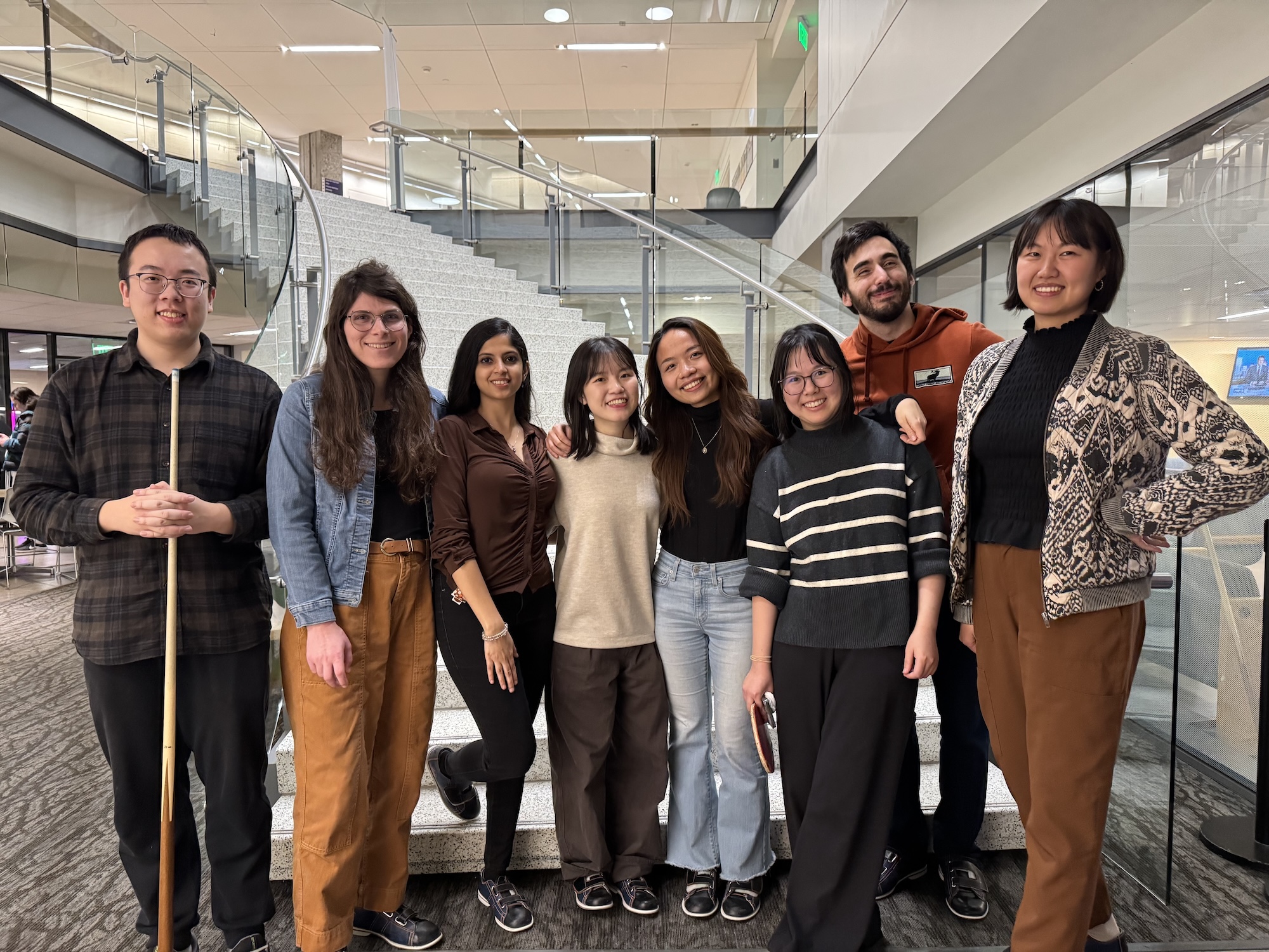 photo of lab members standing in front of a staircase