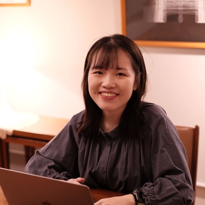 photo of Yili smiling while sitting at a desk with a laptop