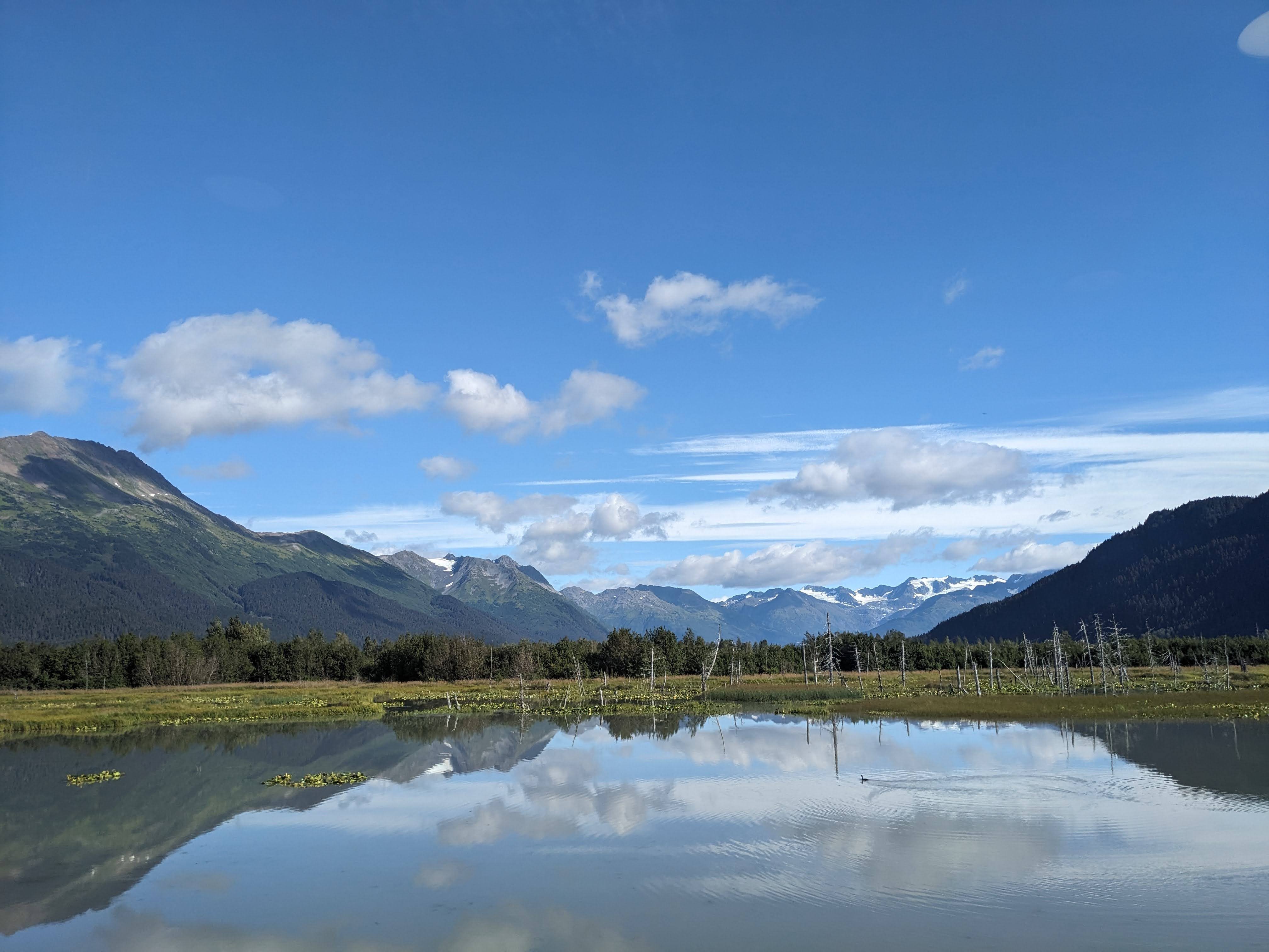 photo of lake and mountains in the background on train from anchorage to whittier