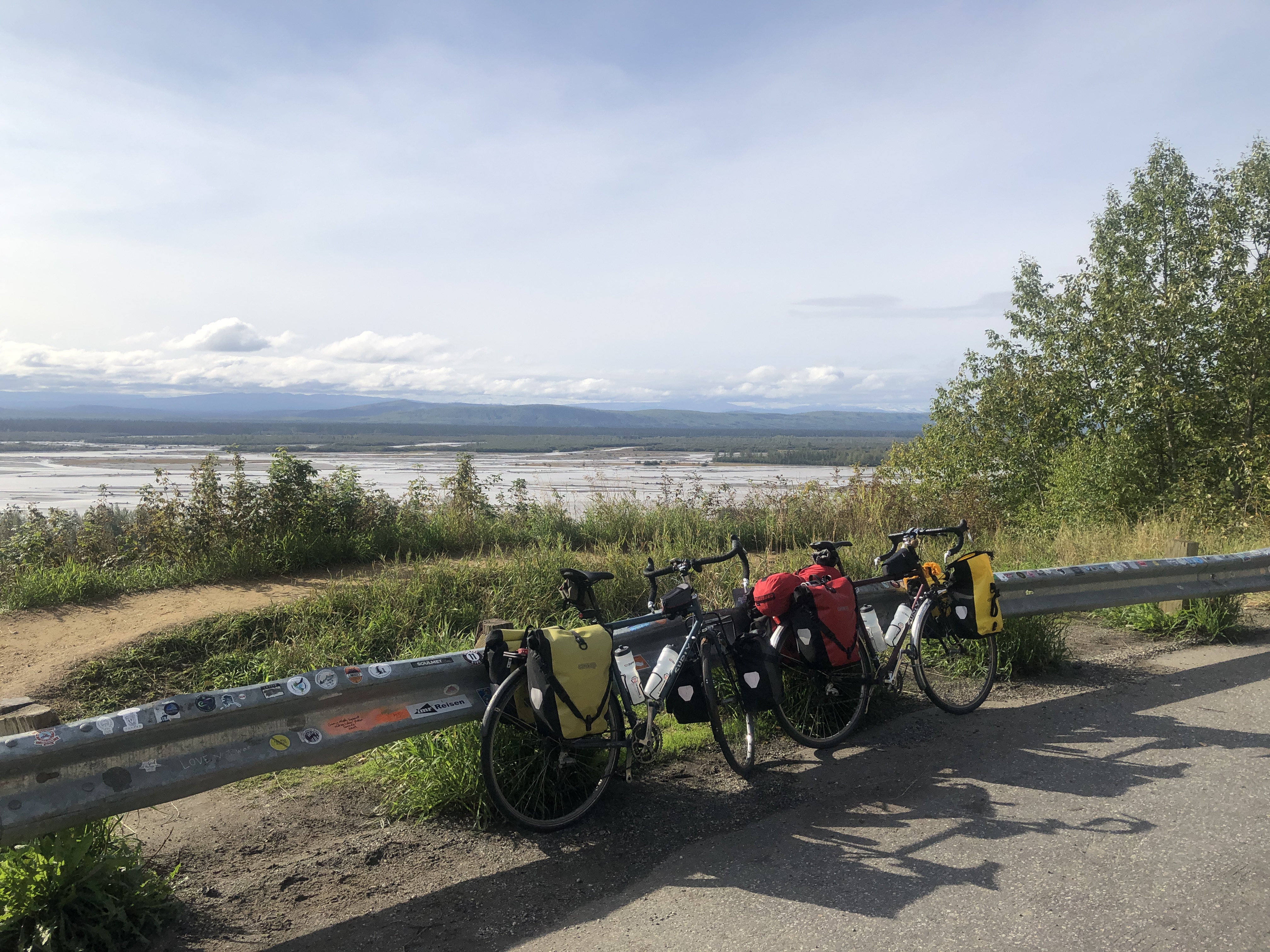 two bikes leaning against road dividers with a river delta in the distance